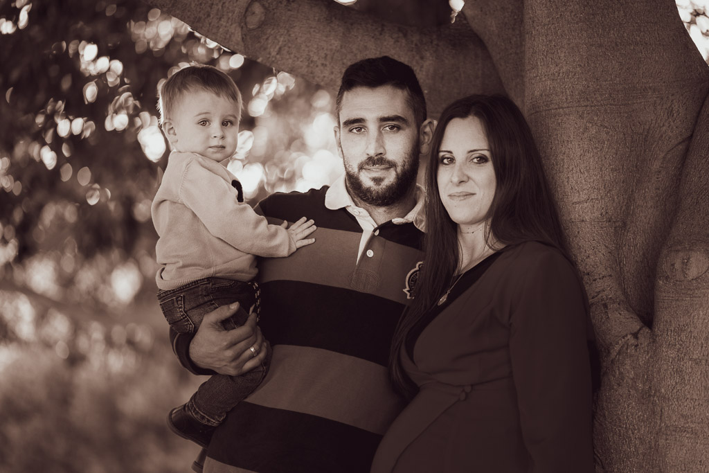 fotografía familia en blanco y negro en el parque con mujer embazada y niño pequeño