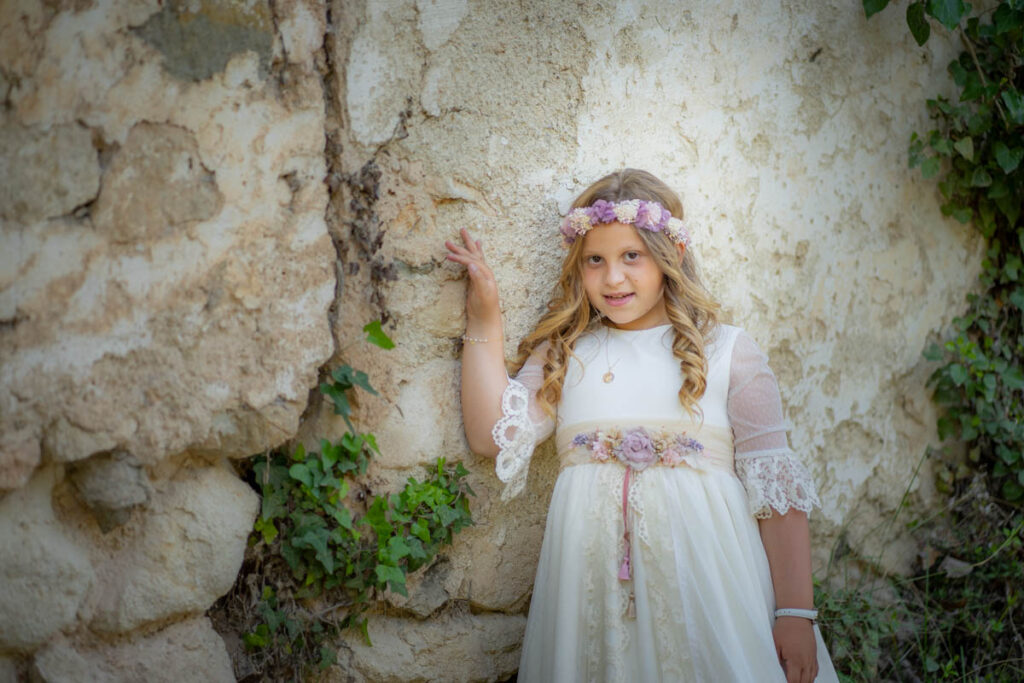 foto de niña con traje comunión en pared