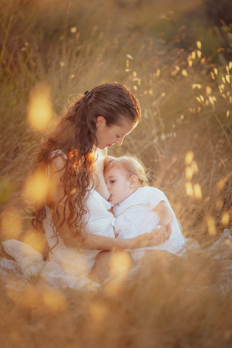 Sesión de fotos en el campo de Lactancia Materna Capturando la Maternidad. Madre e hija disfrutando de un momento único mientras crean recuerdos.