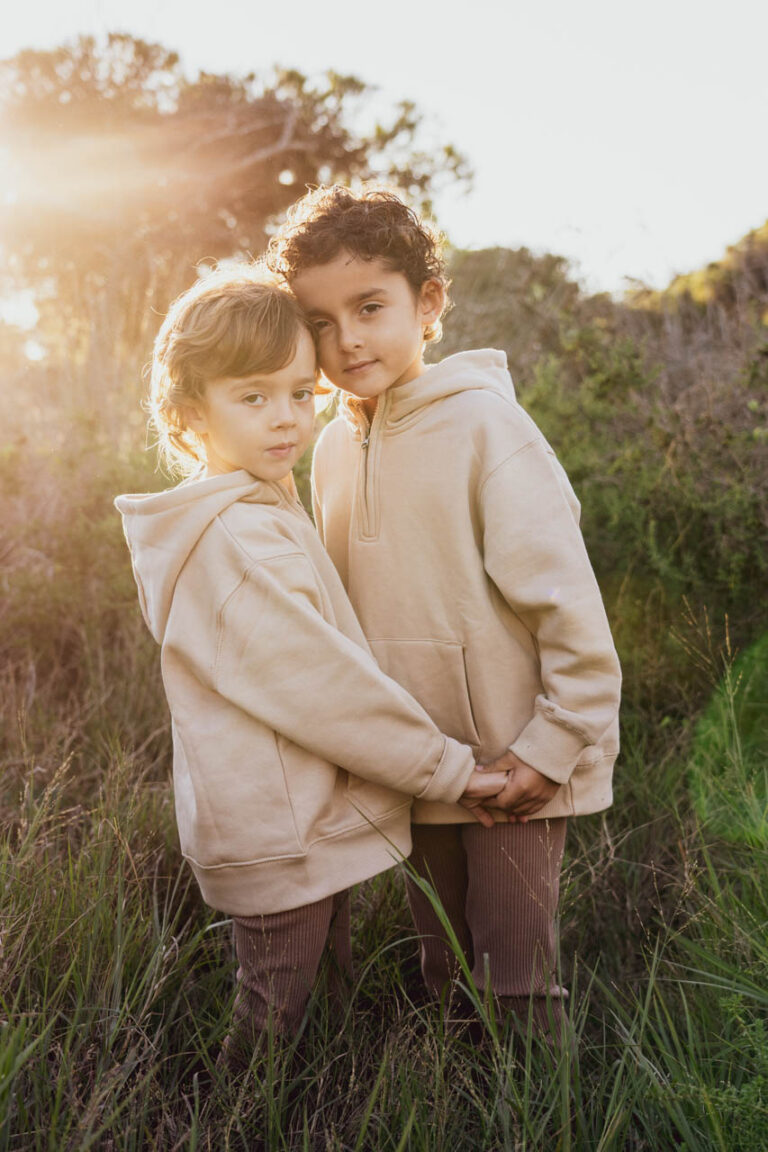 Sesión de hermanos pequeños jugando alegremente en el campo. Momentos llenos de diversión, risas y conexión familiar